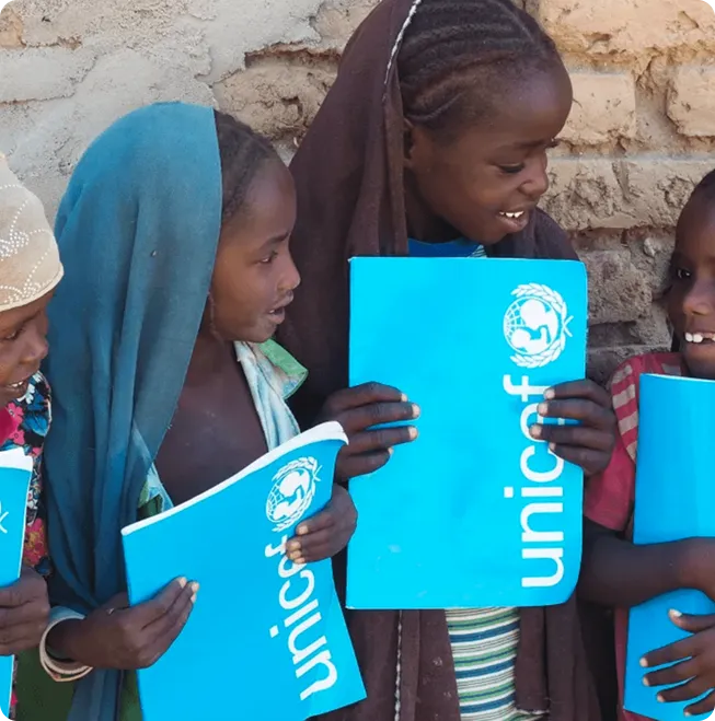 piger med unicef bøger der smiler og er glade