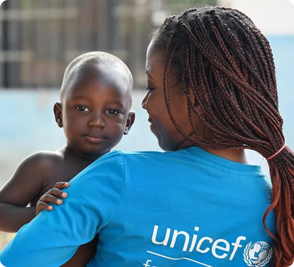kvinde der holder en baby og har en blå unicef trøje på